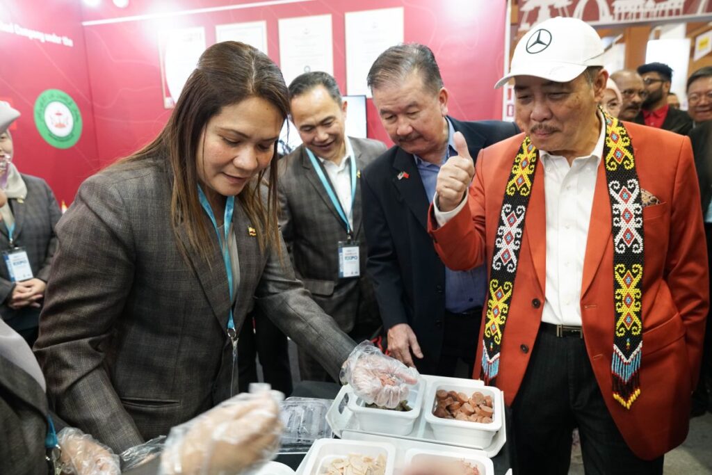 Sabah Chief Minister Datuk Hajiji Noor giving the thumbs up after trying products from PDS' booth at the Brunei pavilion at SIE.